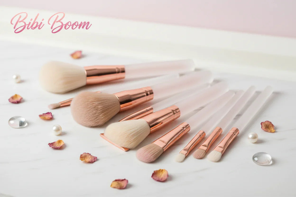 Set de brochas de maquillaje Bibi Boom con mangos rosados, sobre mesa blanca decorada.
