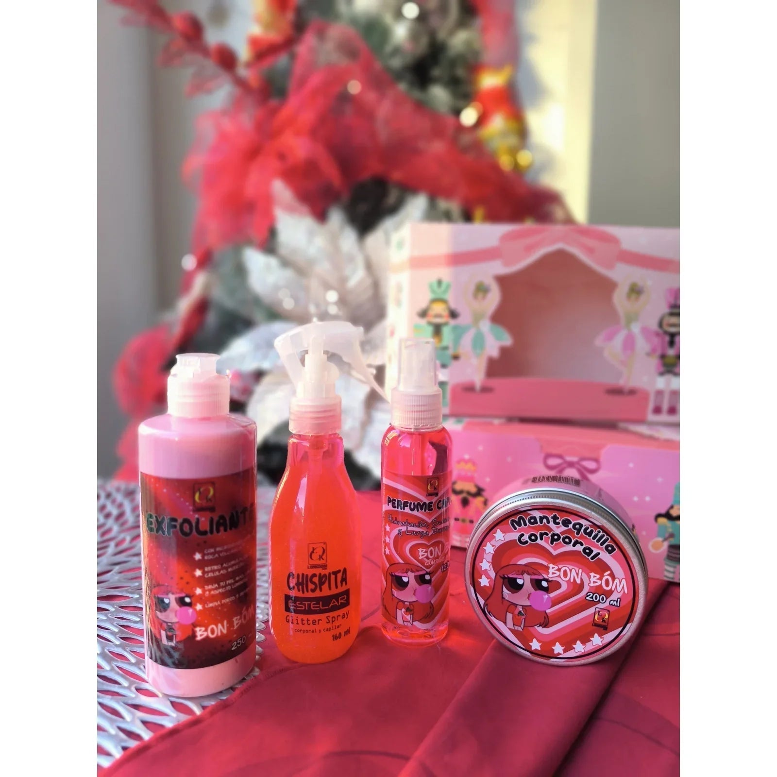 Kit de belleza infantil Bon Bon con exfoliante, perfume, glitter y mantequilla corporal, frente a árbol de Navidad. Productos de Bibi Boom.