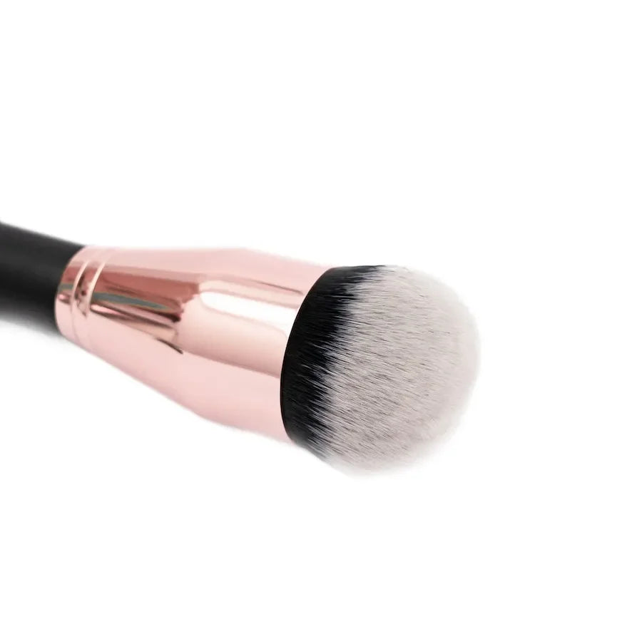 Detalle de brocha para aplicar base de maquillaje con cerdas suaves bicolor, diseñada para difuminar base líquida sin dejar líneas.