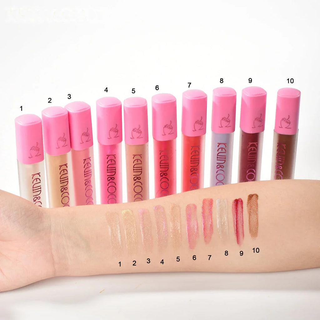 Kit de 10 lip gloss Bibi Boom con tapa rosa y muestras de colores en brazo, maquillaje y belleza.