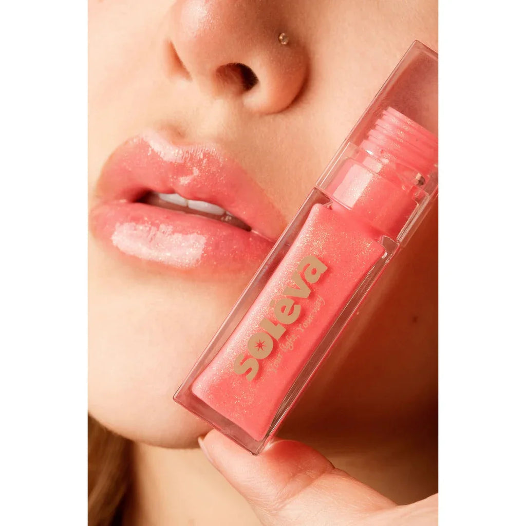 Brillo Labial Líquido Soléva tono glossy aplicado en labios, acabado brillante y natural, ideal para cualquier look de maquillaje.